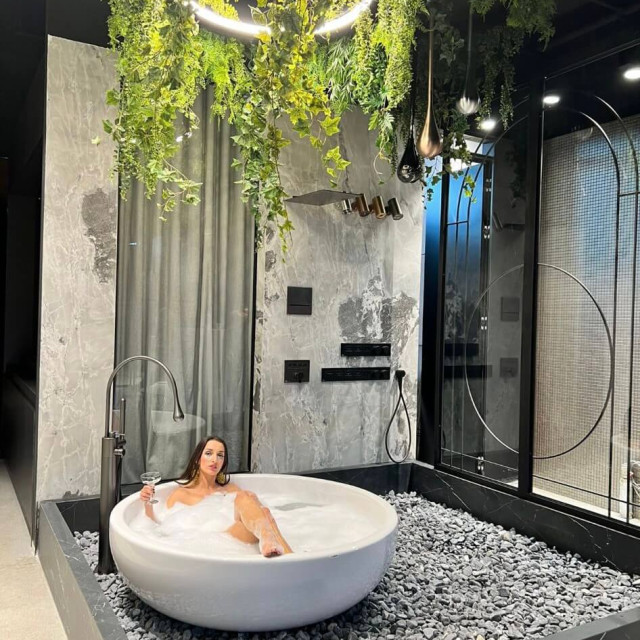 A round bathtub with a woman sitting in it in the EURODOM TILE & STYLE store