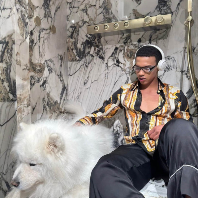 Muškarac sedi u tuš kabini sa psom u EURODOM salonu opreme za kupatila