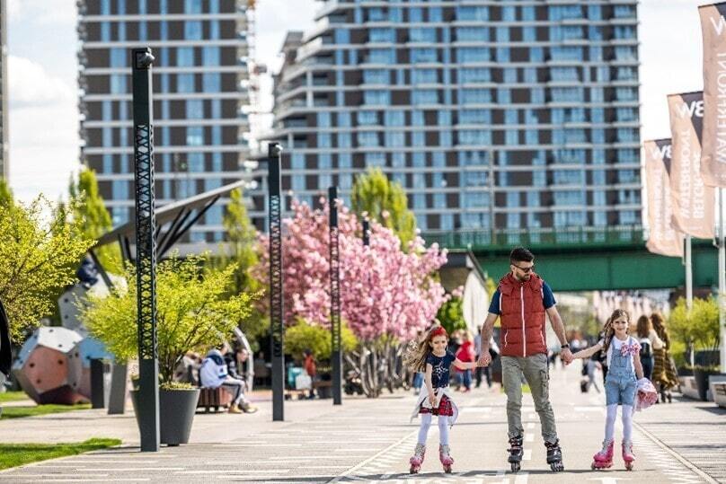 Children ride roller skates on the track, while one of the Belgrade Waterfront buildings can be seen in the background.