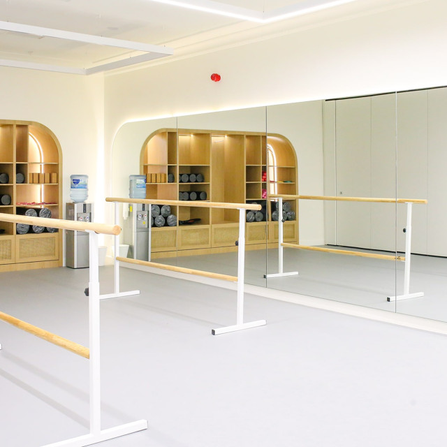 Contemporary dance studio space with a mirrored wall along the entire length.